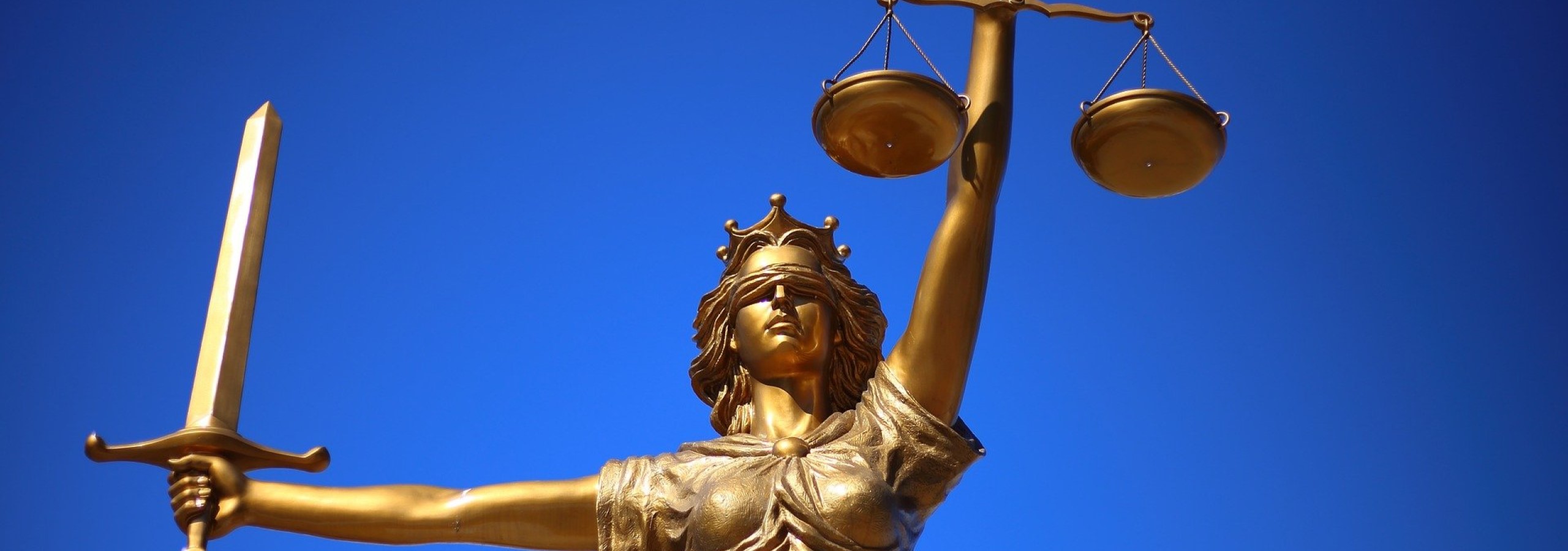 Ortsgericht Tann - Panoramaschnitt des Bildes einer "Justizia"-Statue vor blauem Himmel